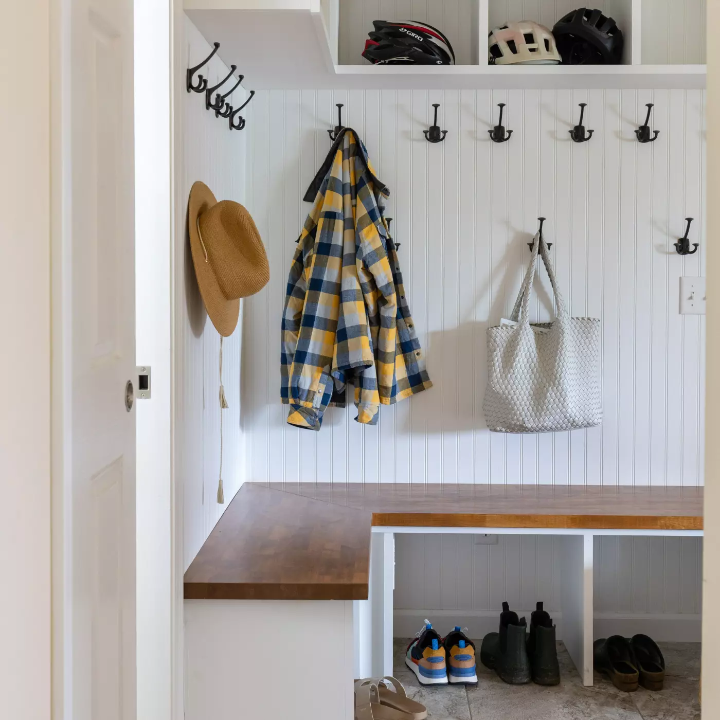 Cozy mudroom with hooks, a bench, and storage for hats, jackets, and shoes.