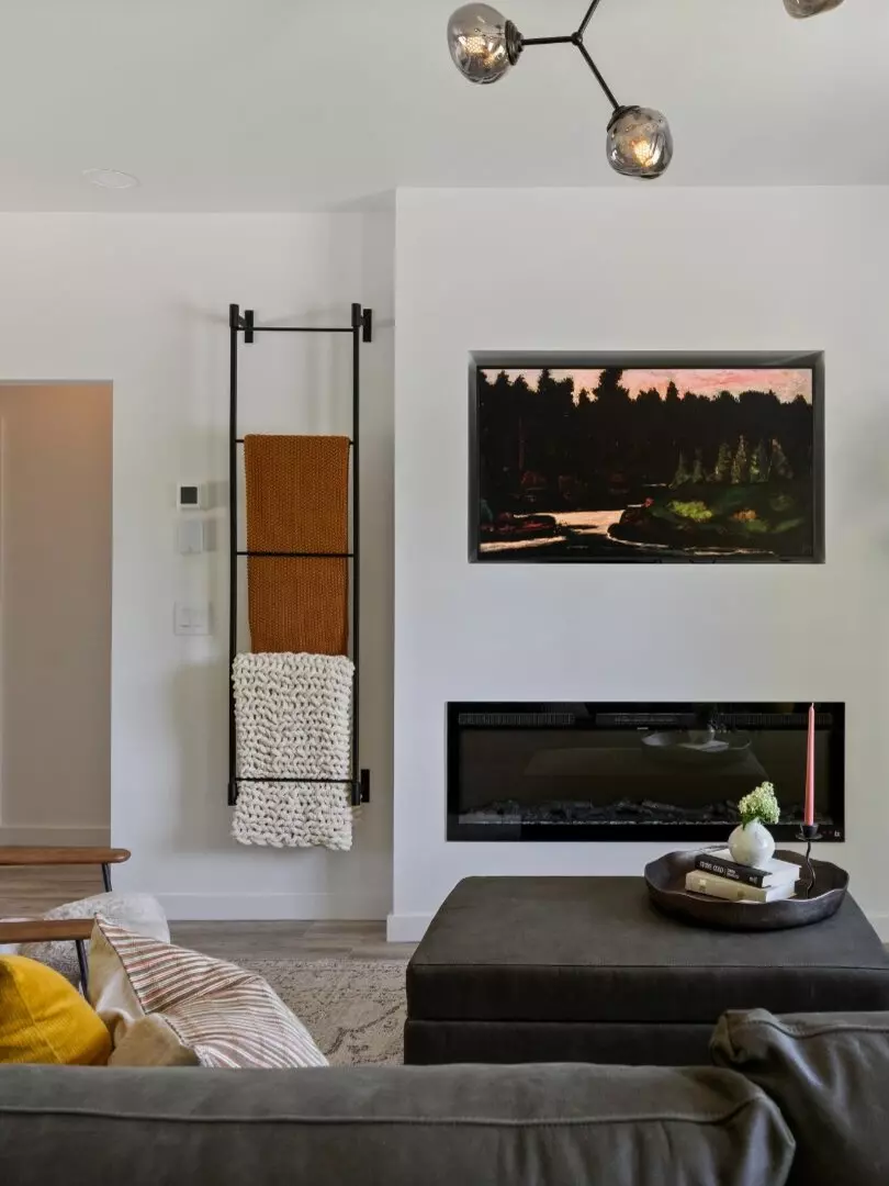 Cozy living room with modern decor, artwork, and layered textiles.