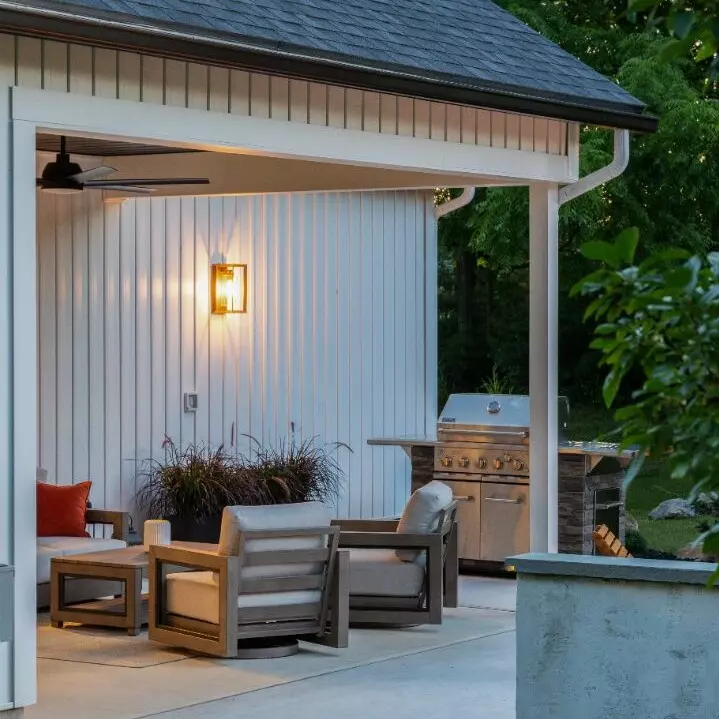 Cozy outdoor seating area with a grill and soft lighting.