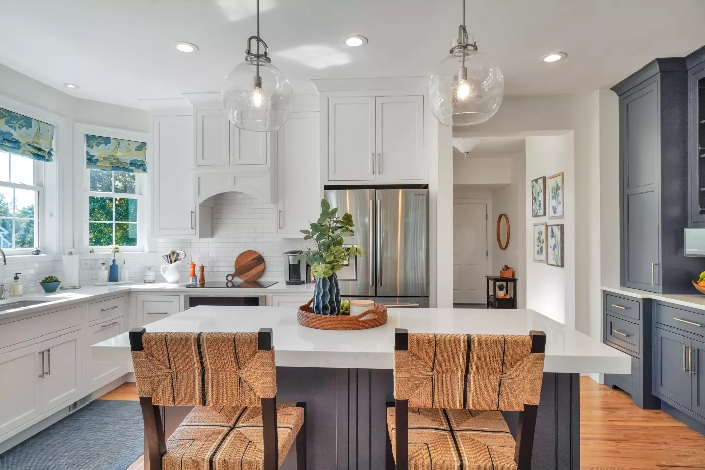 Bright modern kitchen with white cabinets, a marble countertop, and stylish seating.
