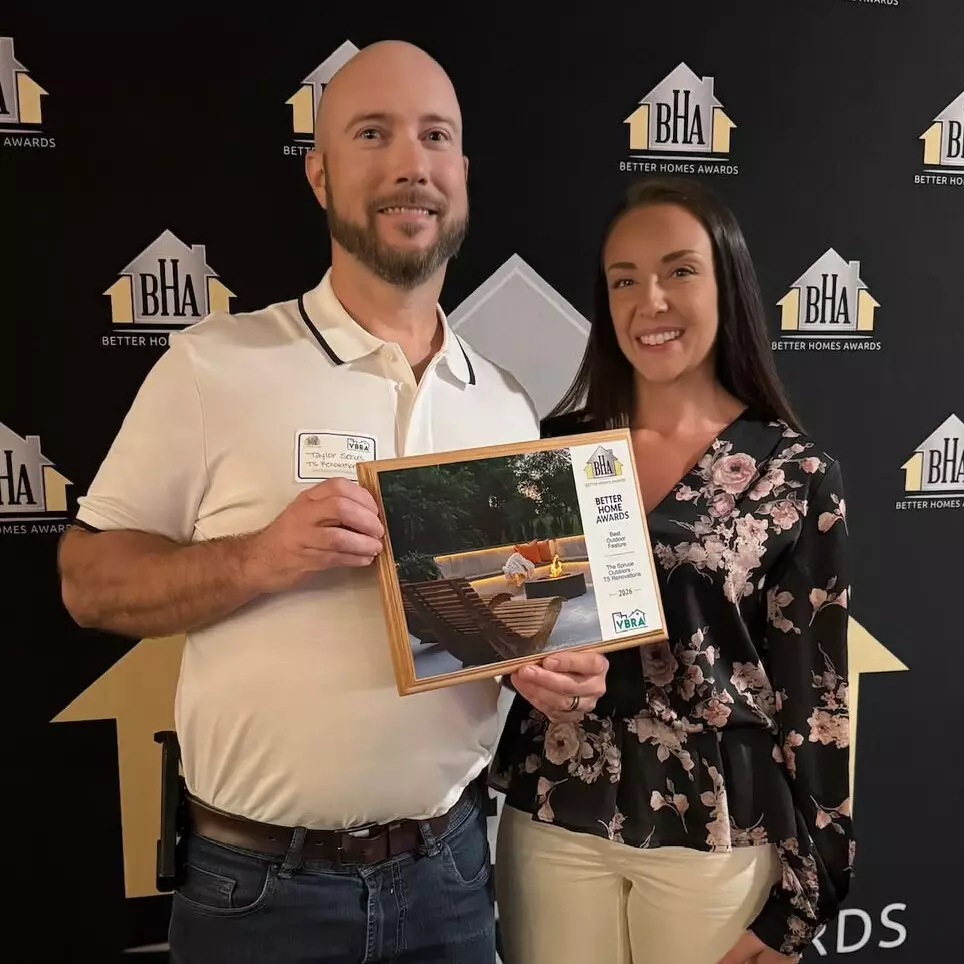 Two people hold an award at a Better Homes Awards event.