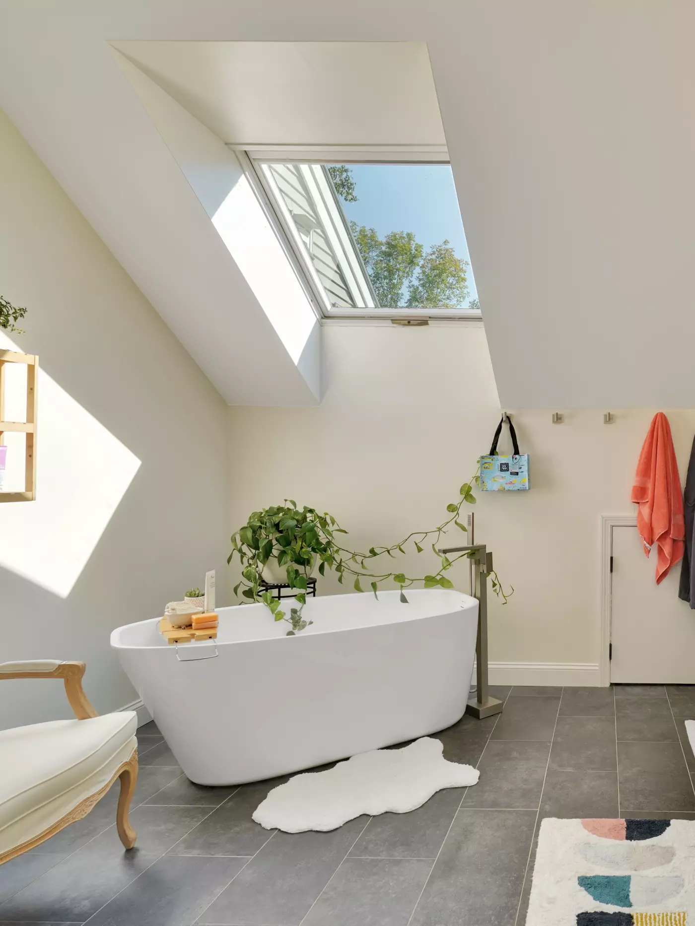 Bright modern bathroom with a freestanding tub, plants, and a skylight.