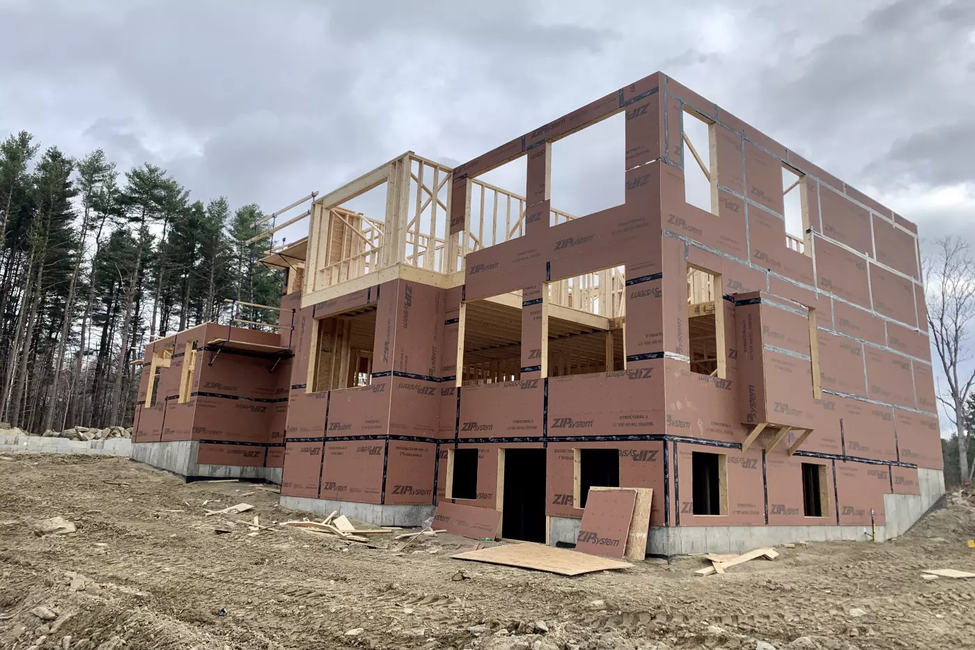 Newly constructed home with exposed framing and wrapped in protective material.