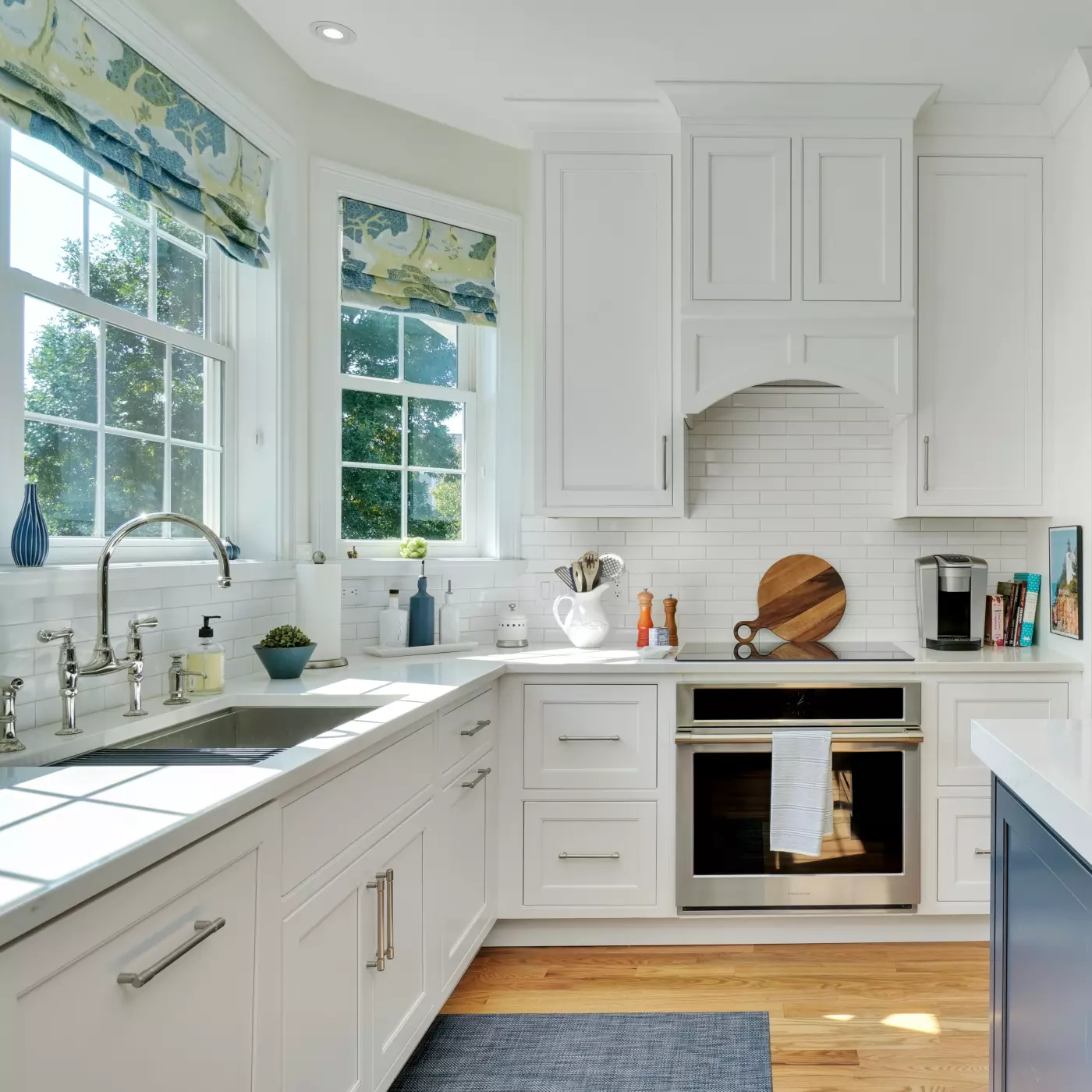 Bright modern kitchen with white cabinets, stainless appliances, and natural light.
