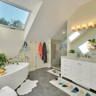 Bright, modern bathroom with a freestanding tub, plants, and stylish decor.