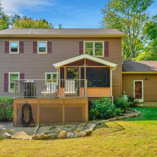 Two-story beige home with a raised wooden deck and screened gazebo overlooking the backyard.