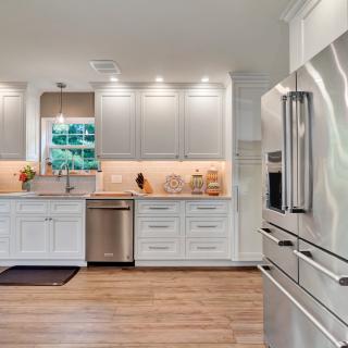 Modern kitchen with white cabinets, stainless steel appliances, and decorative accents.