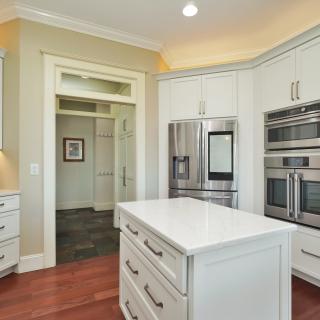 Modern kitchen with white cabinetry, stainless steel appliances, and a central island.