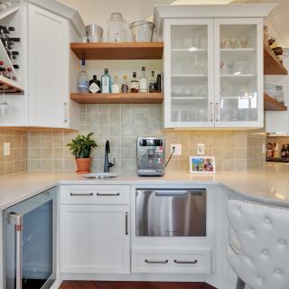 Modern kitchen featuring wine storage, bar area, and stainless appliances.