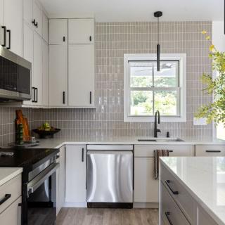 Modern kitchen with white cabinetry, stainless steel appliances, and natural light.