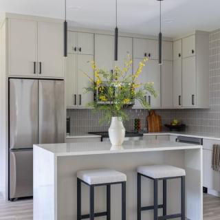 Modern kitchen with sleek cabinetry, a marble island, and floral decor.