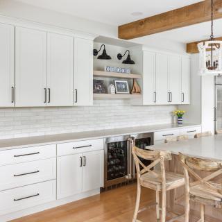 Modern kitchen featuring white cabinets, wood accents, and a large island with seating.