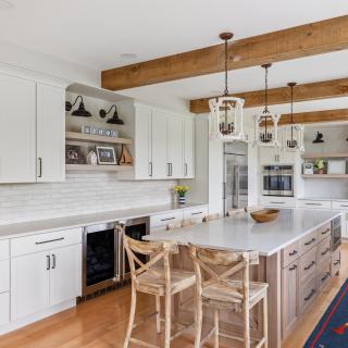 Bright modern kitchen with wood accents, white cabinets, and island seating.