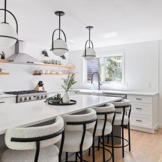 Modern kitchen with white cabinetry, gray accents, and a spacious island with bar stools.