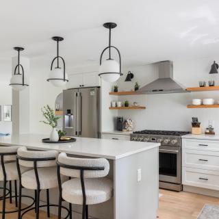 Modern kitchen with white cabinets, gray countertops, and stylish pendant lighting.