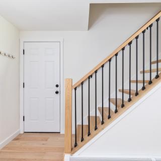 Interior view of a modern entryway with a staircase and white walls.